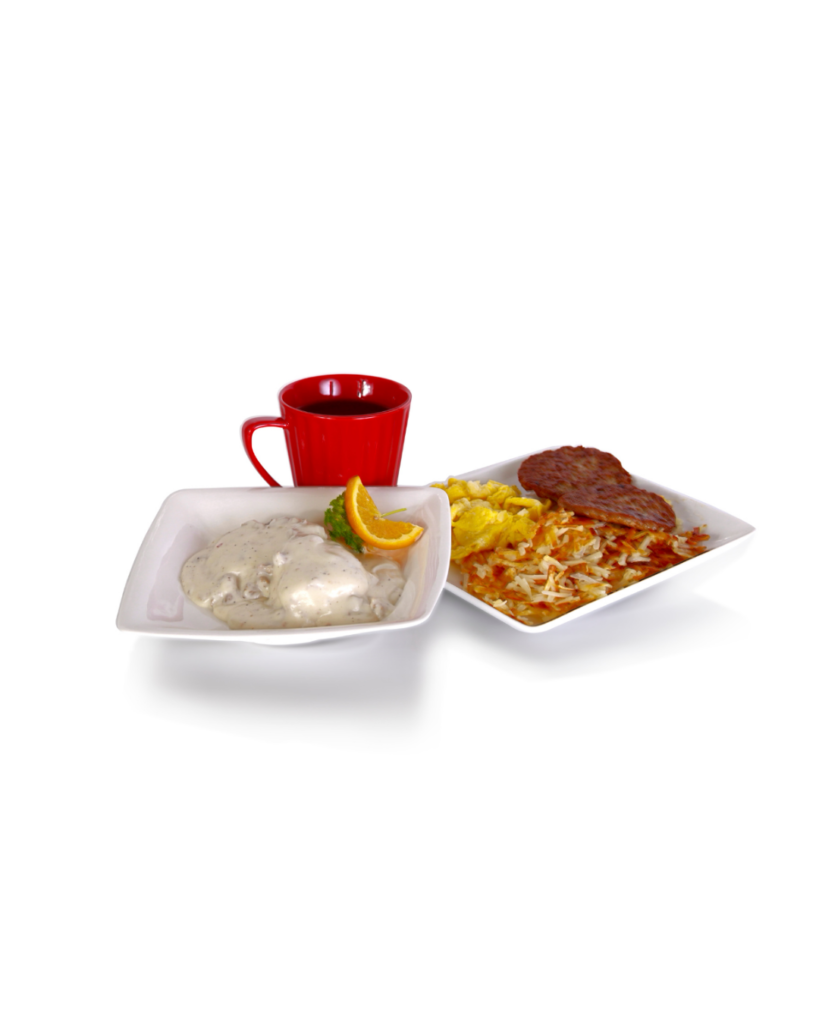 Two white plates show a breakfast creamy chicken in white sauce with an orange slice garnish and a plate of hash browns with eggs and a beef patty with a red mug in the background