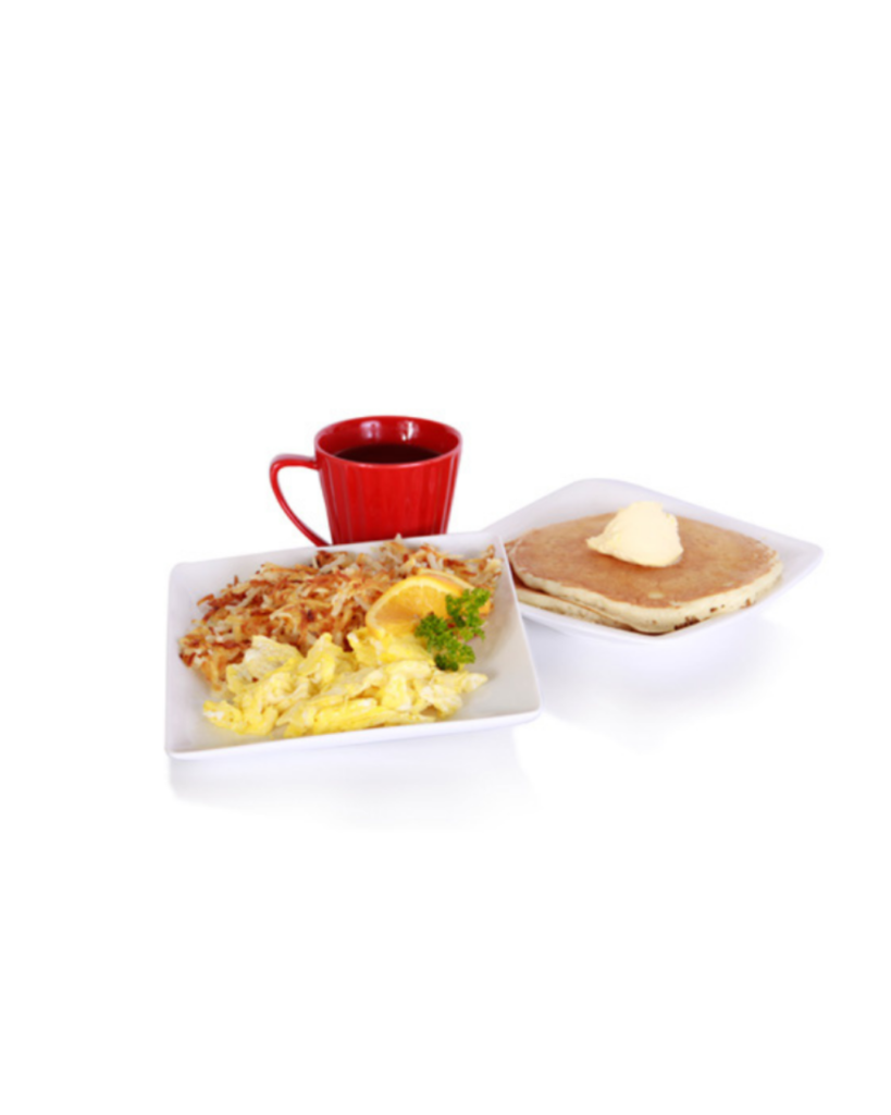 Breakfast plate with scrambled eggs hash browns an orange slice parsley pancakes with butter and a red cup of coffee on a white background