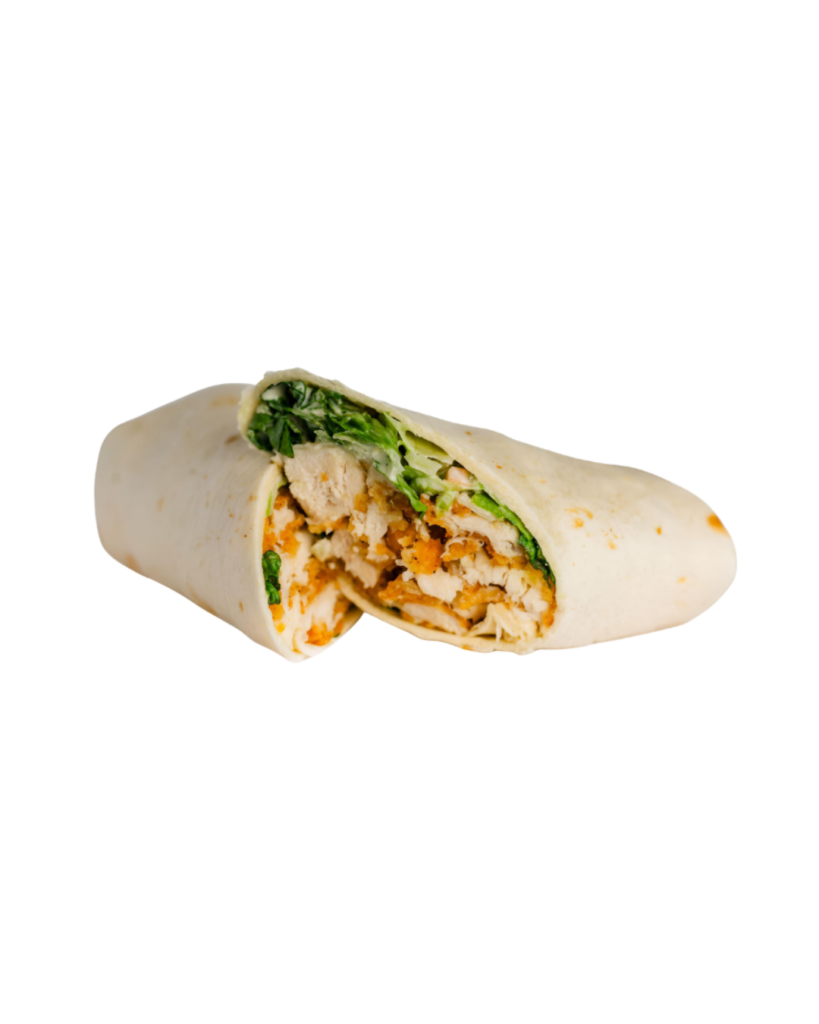 Chicken wrap cut in half showing shredded chicken greens and carrot fills inside a soft tortilla on a white background
