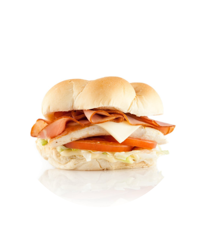 Layered deli sandwich on a soft bun with bacon sliced turkey cheese tomato and lettuce
