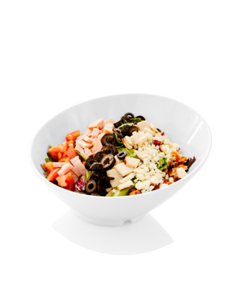 White bowl of mixed salad with tomatoes black olives cheese ham greens and croutons