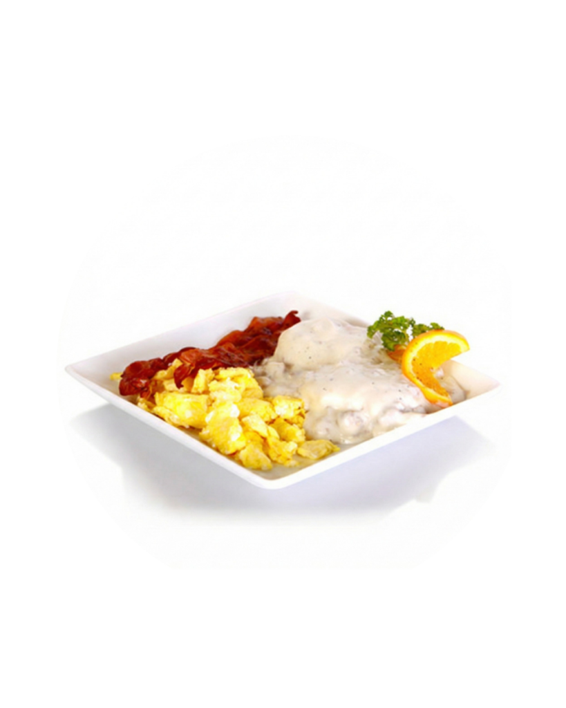 Breakfast plate with scrambled eggs crispy bacon hash browns and a peppery creamy gravy over meat garnished with orange slice and parsley