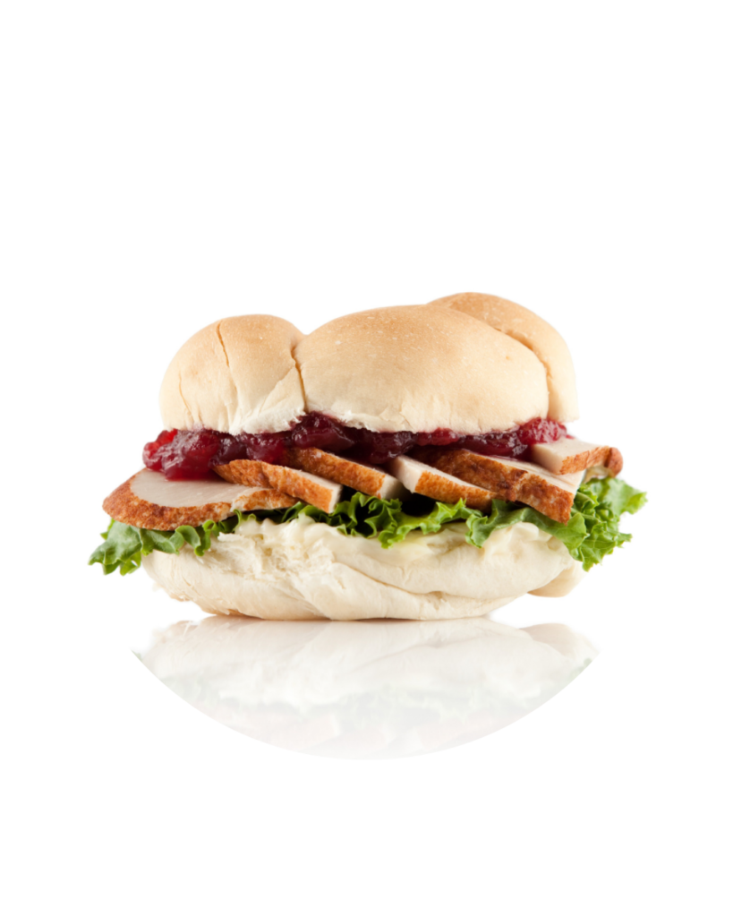 Sandwich with a soft bun lettuce sliced turkey and cranberry sauce showing between the halves on a white background with a circular crop