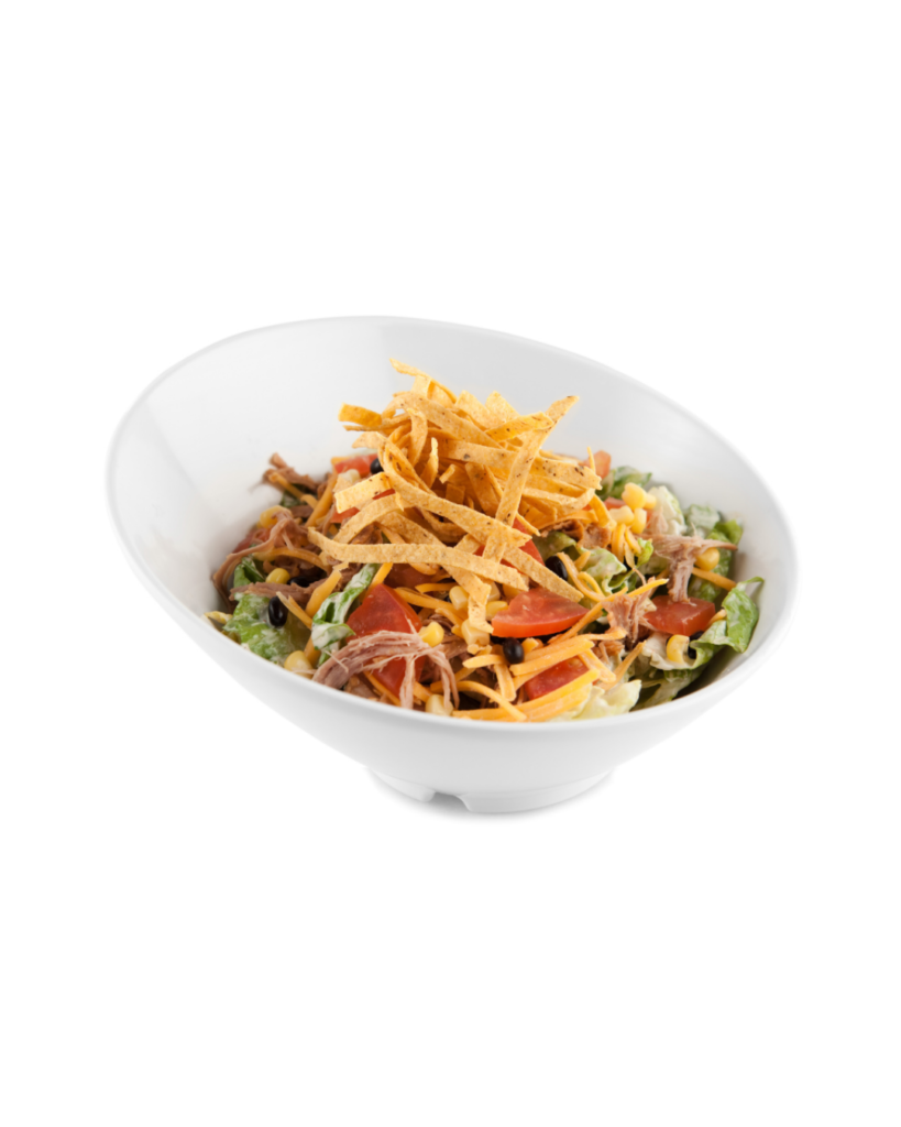 Bowl of mixed salad with greens corn tomatoes shredded cheese and crispy tortilla strips on top