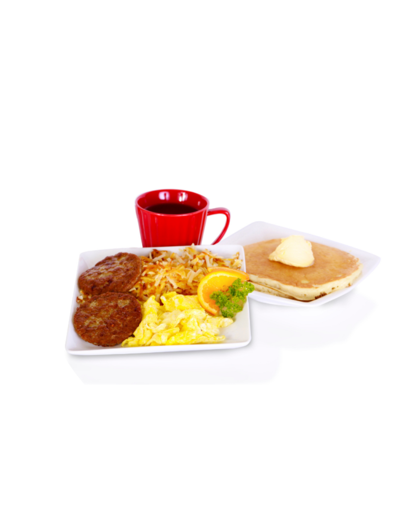 Breakfast platter with scrambled eggs hash browns sausage patties orange slice and parsley plus pancakes with butter on the side and a red mug of coffee or tea in the background
