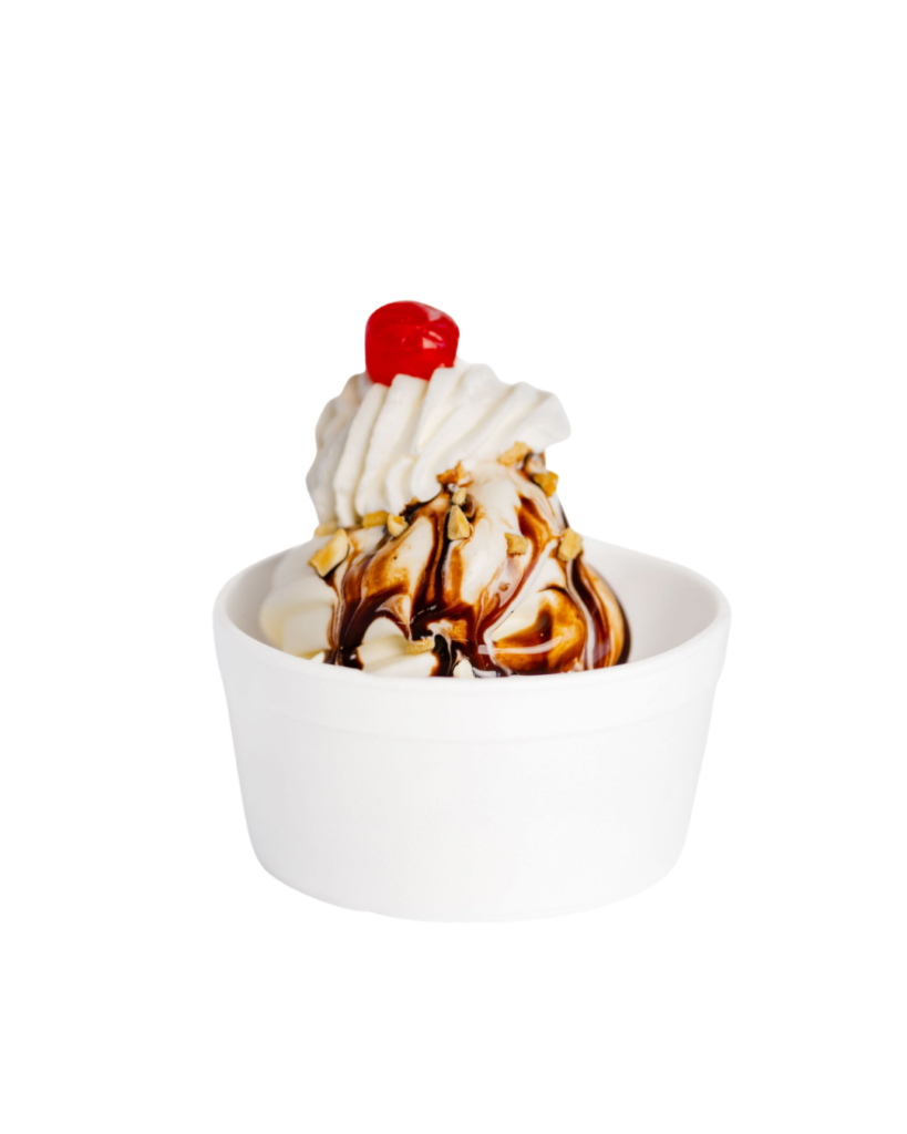 Vanilla ice cream sundae in a white cup topped with whipped cream chocolate sauce chopped nuts and a cherry atop