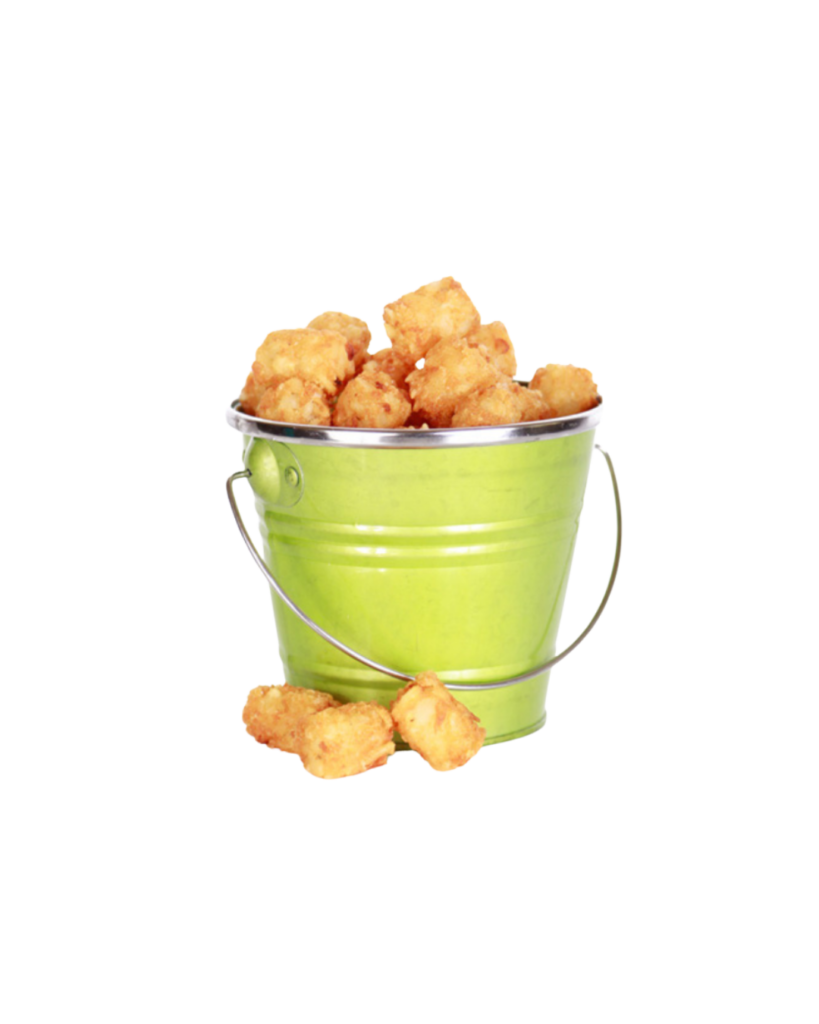 Green metal bucket overflowing with golden fried chicken nuggets with a few pieces lying on the surface nearby