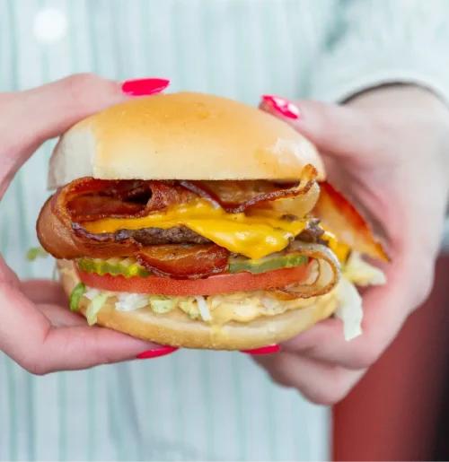 Juicy Warrens burger served with crispy fries, showcasing a classic summer meal at a Northern Utah restaurant.